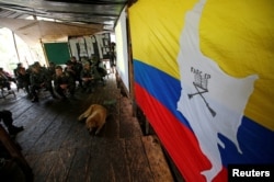 Members of the 51st Front of the Revolutionary Armed Forces of Colombia (FARC) listen to a lecture on the peace process between the Colombian government and their force at a camp in Cordillera Oriental, Colombia, Aug. 16, 2016.