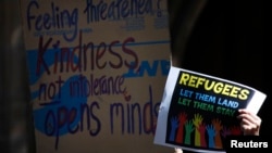 FILE - Protesters hold placards at the 'Stand up for Refugees' rally held in central Sydney, Oct. 11, 2014. 