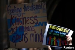 FILE - Protesters hold placards at the 'Stand up for Refugees' rally held in central Sydney, Oct. 11, 2014.