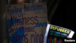 FILE - Protesters hold placards at a Stand up for Refugees rally in central Sydney, Oct. 11, 2014. For at least a year, demonstrators have demanded changes to the Australian government's tough policies on granting asylum. 