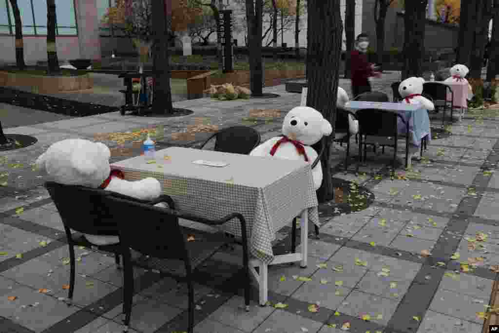 Tables and chairs are placed with hand sanitizers and stuffed toys while maintaining social distancing in downtown Seoul, South Korea.