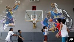 Boys plays at the &quot;House of Kobe&quot; basketball court in Valenzuela, north of Manila, Philippines. Fans left flowers and messages on the walls at the newly inaugurated court after learning of Bryant&#39;s death. Bryant died in a helicopter crash.