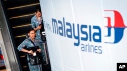 A Malaysia Airlines flight crew heads for the departure lounge at Kuala Lumpur International Airport. Malaysian civil aviation authorities officially declared the airline's Flight MH370 crash an accident on Jan. 29, 2015.