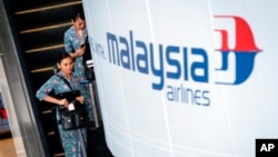 A Malaysia Airlines flight crew heads for the departure lounge at Kuala Lumpur International Airport. Malaysian civil aviation authorities officially declared the airline's Flight MH370 crash an accident on Jan. 29, 2015.