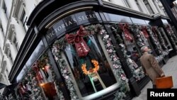 FILE - A man walks past a Christmas seasonal display at a Victoria's Secret lingerie flagship store in London, Dec. 6, 2018.