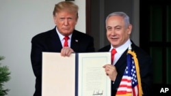 도널드 트럼프 미국 대통령과 베냐민 네타냐후 이스라엘 총리가 25일 골란고원에 대한 이스라엘의 주권을 인정하는 포고문을 들고 포즈를 취하고 있다. 