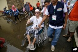 Said Salic, the husband of Rohaina Salic (center), is pushed on a wheelchair after they fled their homes in Marawi city, southern Philippines. It’s unclear how many people remain trapped in Marawi. Authorities have put the figure at anywhere from 100 to 2,000.