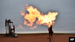 FILE - In this illustrative photo, a flare burns natural gas at an oil well. Taken 8.26.2021