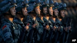 Soldiers of China's People Liberation Army (PLA) stand in line in front of Tiananmen Gate in Beijing as they prepare to march in a military parade to observe the 70th anniversary of the end of World War II in Beijing Thursday Sept. 3, 2015. (Jason Lee/Pool Photo via AP)