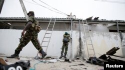 Security personnel are seen at the site of an overnight gunbattle between troops and suspected Islamist militants, on the east coast of Sri Lanka, in Kalmunai, Apr. 27, 2019.