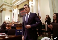 FILE - California Gov. Gavin Newsom receives applause after delivering his first state of the state address to a joint session of the legislature at the Capitol in Sacramento, Calif., Feb. 12, 2019.