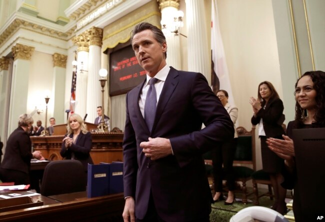 FILE - California Gov. Gavin Newsom receives applause after delivering his first state of the state address to a joint session of the legislature at the Capitol in Sacramento, Calif., Feb. 12, 2019.