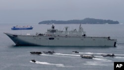 FILE - Royal Australian Navy HMAS Adelaide cruises alongside landing crafts with Philippine Marines and Australian troops as they conduct a joint Humanitarian Aid and Disaster Relief (HADR) exercise off Subic Bay in northwestern Philippines. 