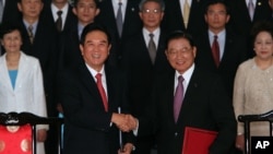 Chen Yunlin, left, shakes hands with Chiang Pin-kung, after signing investment protection pact, Taipei, Taiwan, August 9, 2012. 