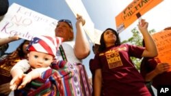 FILE - Activists demand that Mexico better protect the rights of people crossing the country, outside the Mexican Consulate in Los Angeles, July 3, 2014. The U.S. may house migrant kids at an Army National Guard base in California, the Pentagon said.