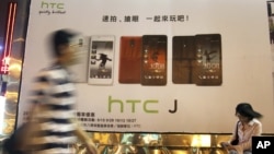 Man walks past an advertising board of Taiwan's smartphone maker HTC Corp. in Taipei, Taiwan, October 25, 2012.