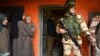 FILE - An Indian paramilitary soldier stands guard as voters stand in a queue to cast their ballots during the District Development Council and Panchayat by-elections at a polling station in Najan Sumbal area of Bandipora district, Dec. 1, 2020.