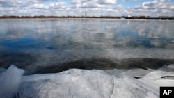 The Washington Monument is seen in the distance reflected in the frozen Potomac River, Jan. 1, 2018, from Arlington, Virginia, near Washington, D.C., as temperatures hover below freezing as a cold snap continues in the region.