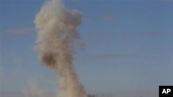 Smoke rises from a military army base which fell to anti-Gadhafi rebels following an air strike by Libyan warplanes in Ras Lanouf, eastern Libya, March 6, 2011