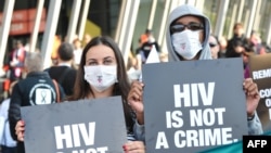 Activistas com cartazes que dizem "VIH não é um crime" numa manifestação em Melbourne, durante a conferência Internacional da SIDA, Julho 22, 2014. 