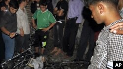 Warga Palestina berkerumun di dekat sepeda motor yang hancur akibat serangan udara Israel di Jabalia, Jalur Gaza utara (13/10).