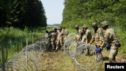 Tentara Lituania memasang kawat berduri di perbatasan dengan Belarus di Druskininkai, Lituania, 9 Juli 2021. (Foto: Janis Laizans/Reuters)