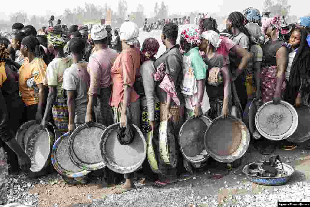 Women wait in line to collect their pay at Pissy Granite Mine in the center of Ouagadougou, Burkina Faso, Jan. 29, 2022.