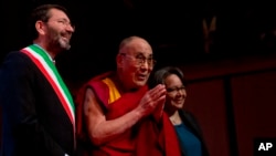 Tibetan spiritual leader the Dalai Lama (C), flanked on left by Rome's Mayor Ignazio Marino, arrives at the opening of the World Summit of Nobel Peace Laureates in Rome, Dec. 12, 2014.