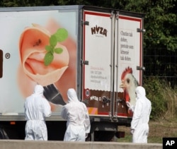 Investigators stand near a truck that stands on the shoulder of the highway A4 near Parndorf south of Vienna, Austria, Thursday, Aug 27, 2015.