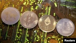 FILE - Representations of the Ripple, Bitcoin, Etherum and Litecoin virtual currencies, Feb. 13, 2018. Switzerland's government wants to look into the feasibility of launching its own state-backed cryptocurrency.