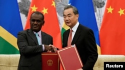 FILE - Chinese State Councilor and Foreign Minister Wang Yi shakes hands with Jeremiah Manele during a ceremony in Beijing, Sept. 21, 2019. Manele was selected as the new prime minister of the Solomon Islands on May 2, 2024.