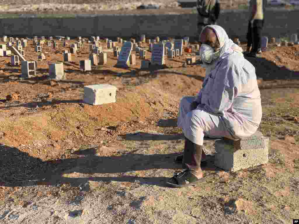 A man sits by the graves of the flash flood victims in Derna, Libya, Friday, September 15, 2023. The death toll in Libya&#39;s coastal city of Derna has soared to over ten thousand as search efforts continue following a massive flood fed by the breaching of two dams in heavy rains, the Libyan Red Crescent said.&nbsp;