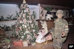 A United States soldier stands guard by a Christmas tree inside the house of Manual Noriega in Panama City, Dec. 23, 1989. U.S. troops are still searching for the deposed Panamanian leader.