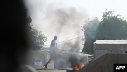 Smoke billows from burning tires in the street during clashes between opposition demonstrators and Chadian police in N'Djamena on April 27, 2021. 