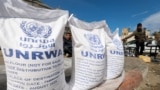 Pengungsi Palestina menunggu untuk menerima bantuan Badan Bantuan dan Pekerjaan PBB (UNRWA), di tengah konflik yang sedang berlangsung antara Israel dan kelompok Islam Palestina Hamas, di Rafah, di selatan Jalur Gaza, 7 Maret 2024. (Foto: REUTERS/Mohammed Salem)
