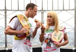 Eleven-time and defending men's champion Joey Chestnut, left, and defending women's champion Miki Sudo pose together during Nathan's Famous international Fourth of July hot dog eating contest weigh-in at the Empire State Building on Wednesday, July…