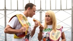 Defending men's champion Joey Chestnut, left, and defending women's champion Miki Sudo pose together during Nathan's Famous international Fourth of July hot dog eating in New York City, in 2019.