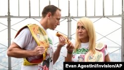 Defending men's champion Joey Chestnut, left, and defending women's champion Miki Sudo pose together during Nathan's Famous international Fourth of July hot dog eating in New York City, in 2019.