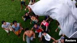 Survivors of Typhoon Haiyan wait for a sack containing food supplies to drop from a Philippine Air Force helicopter in Tolosa, Leyte in central Philippines Nov. 21, 2013.