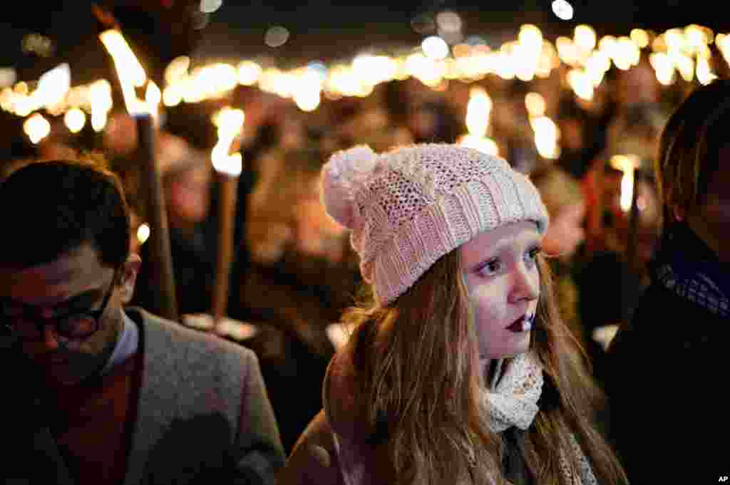 Warga Kopenhagen memegang obor saat berkumpul di alun-alun Kongens Nytorv dekat Kedutaan Besar Perancis di Kopenhagen untuk memberikan penghormatan bagi para korban serangan maut di Paris (15/11). (Polfoto via AP/Philip Davali)