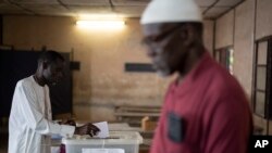 FILE - A man casts his vote for legislative elections, at a polling station in Dakar, Senegal, July 31, 2022