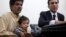 Nine-month-old baby Musa Khan sits on his grandfather's lap before appearing in a court in Lahore, April 12, 2014. 