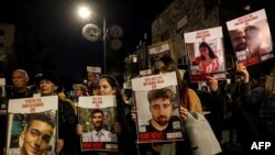 FILE - Protesters hold up portraits during a rally organised by family and supporters of Israeli hostages held in Gaza since the October 7 attacks by Hamas, to demand their release, on January 22, 2024, near the residence of the Israeli prime minister in Jerusalem.