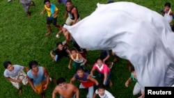 Para penyintas Topan Haiyan menunggu karung berisi bantuan pangan dijatuhkan dari helikopter angkatan udara Filipina di Tolosa, provinsi Leyte di Filipina tengah (21/11). (Reuters/Erik De Castro)