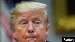 President Donald Trump listens during a small business round-table at the White House in Washington, Dec. 6, 2019. The White House said Friday that Trump would not mount a defense in the impeachment proceedings against him.