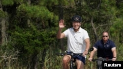 Presiden AS Joe Biden tampak mengendarai sepeda di area Rehoboth Beach, Delaware, pada 11 Agustus 2024. (Foto: Reuters/Kevin Lamarque)