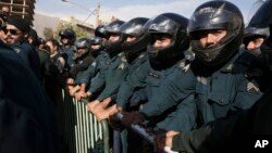 Iranian police officers protect the Saudi Arabian Embassy during a gathering of protesters blaming the Arab country for a deadly stampede that killed more than 700 pilgrims, in Tehran, Iran, Sept. 27, 2015.