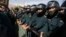 Iranian police officers protect the Saudi Arabian Embassy during a gathering of protesters blaming the Arab country for a deadly stampede that killed more than 700 pilgrims, in Tehran, Iran, Sept. 27, 2015.