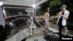 FILE - Visitors look around Rolls-Royce's vintage car during the Rolls-Royce's Concours d'Elegance event for celebrating its ten years of business in China, June 28, 2013. 