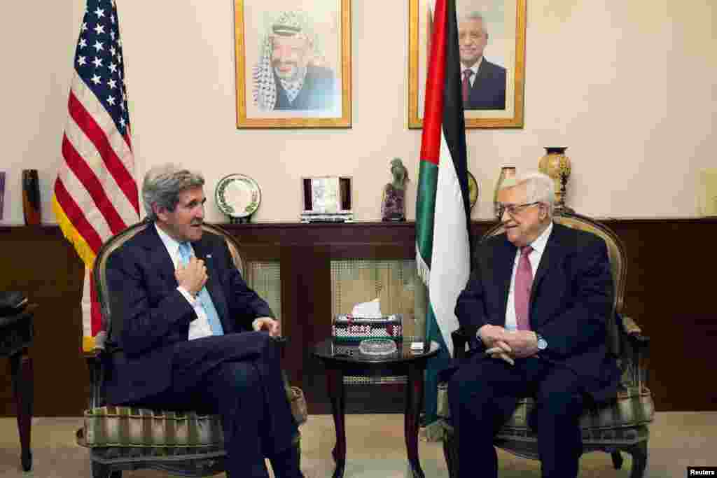 U.S. Secretary of State John Kerry speaks with Palestinian President Mahmoud Abbas in Amman, Japan, June 28, 2013. 